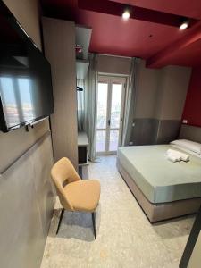 una camera con letto, sedia e televisore di Mia Suites Porto a Napoli Altre 96 foto