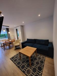 ein Wohnzimmer mit einem blauen Sofa und einem Tisch in der Unterkunft Apartament U Janicka in Zakopane