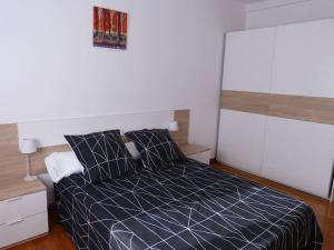 a bedroom with a bed with a blue comforter at Eguzkilore - Apartamento luminoso y soleado in Elizondo