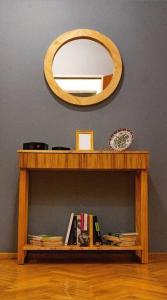 una mesa de madera con espejo y un estante con libros en Clásico y moderno departamento - olivos in 