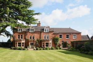 a large brick house with a large lawn at The Cottage, Orgreave Estate in Yoxall