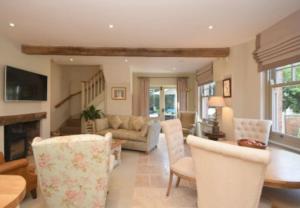 a living room with a couch and a table and chairs at The Cottage, Orgreave Estate in Yoxall