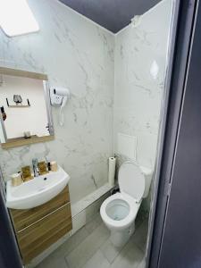HOTEL LOUVAIN في باريس: حمام ابيض مع مرحاض ومغسلة