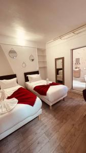 a bedroom with two beds and a mirror at HOTEL LOUVAIN in Paris