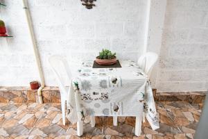Habitaciones privadas, Casa de Amber, Manta في مانتا: طاولة بيضاء عليها كرسيين وزرع