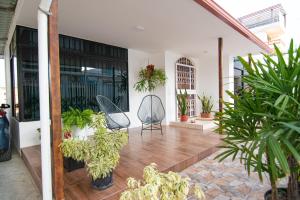 une terrasse avec un bouquet de plantes et une chaise dans l'établissement Habitaciones privadas, Casa de Amber, Manta, à Manta