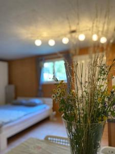 un jarrón con flores sobre una mesa en un dormitorio en Holiday accomodation Coglio, en Maggia