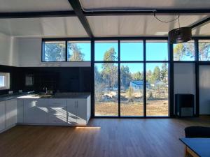 cocina grande con armarios blancos y ventanas grandes en Casa Amancay en San Carlos de Bariloche