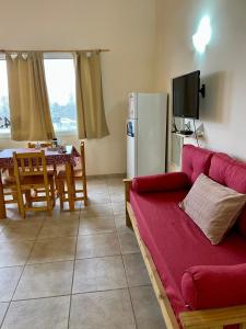 un soggiorno con divano rosso e tavolo di Alboraya apartamentos a Dina Huapi