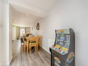 a kitchen and dining room with a table and a refrigerator at Sea View Luxury 5 Star Cottage Near Milford Marina in Pembrokeshire