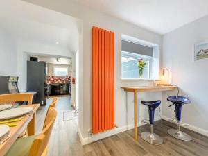 a kitchen and dining room with an orange partition at Sea View Luxury 5 Star Cottage Near Milford Marina in Pembrokeshire