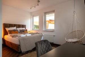 ein Schlafzimmer mit einem Bett und einem Hängesessel in der Unterkunft nidusROOMS: Suite Hockenheim in Hockenheim