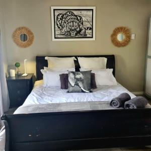 łóżko z białą pościelą i poduszkami w sypialni w obiekcie Angel 8 AirBnB Apartment 1 w mieście Robertson