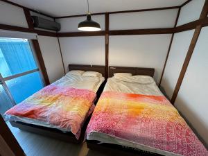 dwa łóżka siedzące obok siebie w pokoju w obiekcie Monster lodge 西伊豆 w mieście Nishina