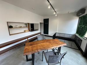une chambre vide avec une table et des chaises en bois dans l'établissement Monster lodge 西伊豆, à Nishina