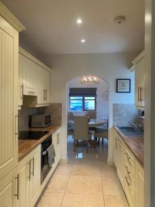 a kitchen with a table and a dining room at Kilronan 4 Bed House on castle grounds in Ballyfarnon