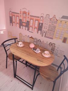 un tavolo di legno con due tazze e piattini sopra di CHESS Apartment a Ventspils Altre 9 foto
