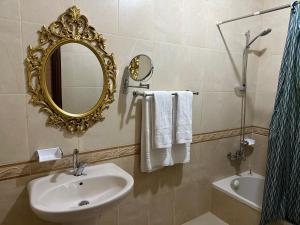 瓦迪穆薩的住宿－Marvel Hostel，浴室配有盥洗盆、镜子和浴缸