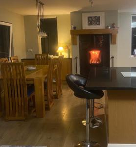 a kitchen and dining room with a table and a fireplace at Ned's Cottage in Kincasslagh