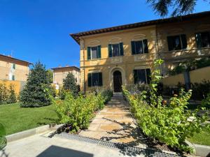 uma casa grande com um jardim em frente em Villa Natalina B&B em Pisa