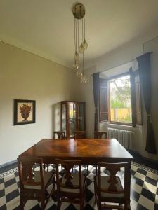 ein Esszimmer mit einem Holztisch und Stühlen in der Unterkunft Villa Natalina B&B in Pisa