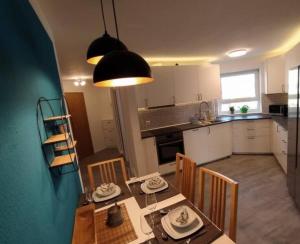 - une cuisine et une salle à manger avec une table et des chaises dans l'établissement Rooftop Apartments - Doppelzimmer Deluxe in Gemeinschaftsunterkunft Weinberg R3, à Ulm