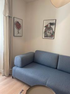 a blue couch in a living room with pictures on the wall at Charmant appartement in Ajaccio