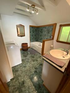 uma casa de banho com uma banheira e um lavatório e uma banheira em L'Oasis em Ascot Corner