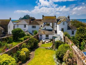 a row of white houses with a garden at Marazion Beach Town House with Private Parking in Marazion