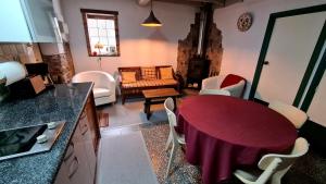 eine Küche und ein Wohnzimmer mit einem Tisch und Stühlen in der Unterkunft Cal Gallo (Vivienda Vacacional) in Riosa