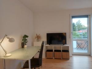 un soggiorno con un tavolo e una televisione di Rooftop Apartments - Doppelzimmer Deluxe in Gemeinschaftsunterkunft Weinberg R3 a Ulma Altre 2 foto