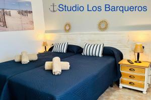 ein Schlafzimmer mit einem blauen Bett und Handtüchern darauf in der Unterkunft El Castillito Studios in Buenavista del Norte
