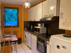 una cocina con electrodomésticos blancos y una ventana en residence du chateau, en Luchon