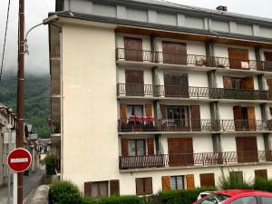 un edificio de apartamentos con balcones y una señal de stop en residence du chateau, en Luchon