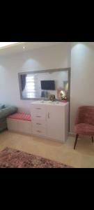 a living room with a desk and a red chair at شقه للايجار المفروش في مدينتي Ad3. 01099725816 in Madinaty