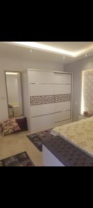 a bedroom with a large bed and a mirror at شقه للايجار المفروش في مدينتي Ad3. 01099725816 in Madinaty
