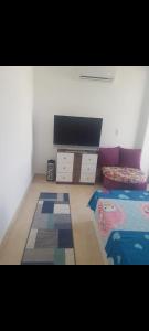 a living room with a flat screen tv and a couch at شقه للايجار المفروش في مدينتي Ad3. 01099725816 in Madinaty