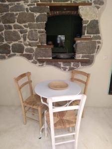 mesa, 2 sillas y horno de piedra en MOLYVOS BOUTIQUE HOUSE, en Mithimna