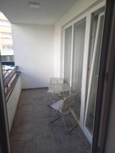 un balcón con 2 sillas y una mesa en un edificio en URBAN 1 Ferizaj City, en Ferizaj