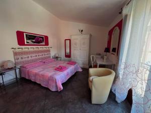 - une chambre avec un lit, une table et une chaise dans l'établissement B&B RosaViola, à Teulada