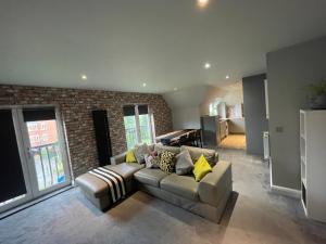 a living room with a couch and a brick wall at Spacious Apartment NEC BHX in Solihull