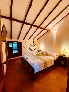 - une chambre avec un grand lit dans l'établissement Hostal Casa Ceiba, à Barichara