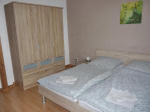 a bedroom with two beds and a wooden cabinet at Ferienwohnung mit Terrasse in der Uckermark in Milmersdorf