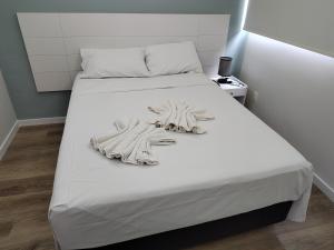 a white bed with white sheets and pillows on it at BOA VIAGEM FLATS APTO 201 in Recife +15 photos