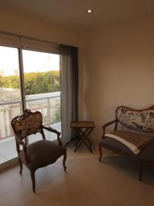 uma sala de estar com duas cadeiras e uma janela em Los Lapachos em Paraná