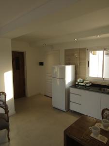 a kitchen with a white refrigerator and a table at Los Lapachos in Paraná