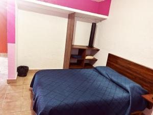 1 dormitorio con 1 cama azul en una habitación en Azomalli en Tepoztlán