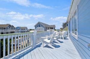 a deck with white chairs on a house at 1606 - Shades of Sand in Corolla
