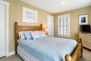 a bedroom with a bed and a television in it at 1606 - Shades of Sand in Corolla