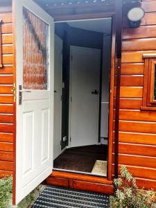 een open deur naar een huis met een veranda bij De Bosuil in Putten